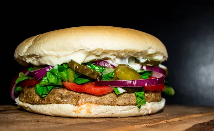 Hamburguesa con lechuga, tomate, cebolla morada y pepinillos